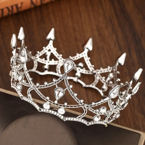 Detailed macro view of silver baroque crown with white crystals on a wooden surface