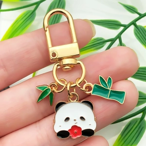Detailed close-up of a golden panda keychain featuring bamboo leaves and enamel charms