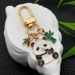 Cute panda metal keychain with bamboo leaves and U-shaped buckle on white artistic stand