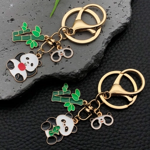 Detailed view of panda keychain featuring bamboo charms and lobster clasp on stone texture