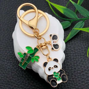 Cartoon panda and bamboo keychain in gold-plated alloy with enamel pendants on display