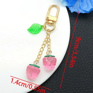 Close-up of strawberry keychain with 9cm length dimensions and resin fruit pendant