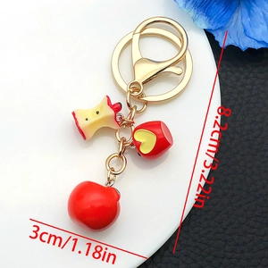 Detailed view of resin apple charms with size labels and golden keychain hooks