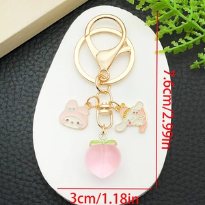 Detail of Cinnamoroll and My Melody keychain with a pink peach and golden metal charms