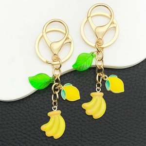 Creative resin fruit keychain featuring yellow banana, lemon charms and green leaf pendant