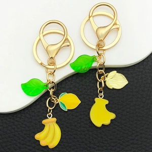 Creative 3D resin fruit keychains featuring yellow banana and lemon with green leaves