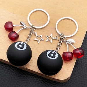 Creative keychain featuring a black billiard number 8 ball, red cherries and silver star