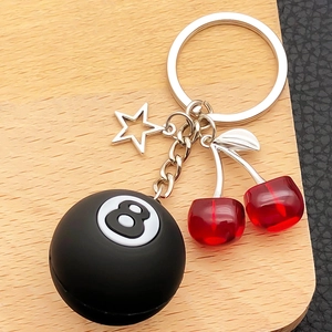 Close-up of creative cherry billiard 8 ball and silver star charms on keychain