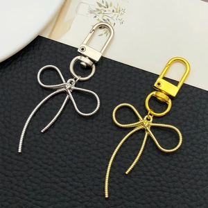 Eleganti portachiavi a forma di fiocco in oro e argento su sfondo bianco e nero