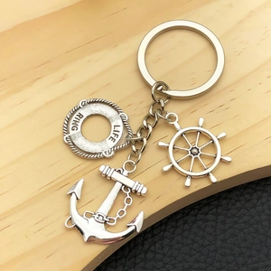 Détail de porte-clés nautiques argentés avec pendentifs bouée de sauvetage, barre et ancre