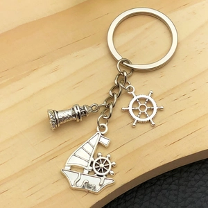 Porte-clés nautique en argent antique avec breloques de phare, gouvernail et voilier détaillés