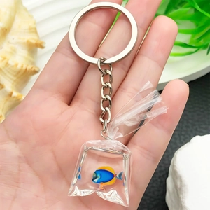 Creative resin blue tropical fish water bag keychain with silver ring held by hand