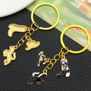Macro detail of western cowboy keychains with enamel horse, boot, and hat charms