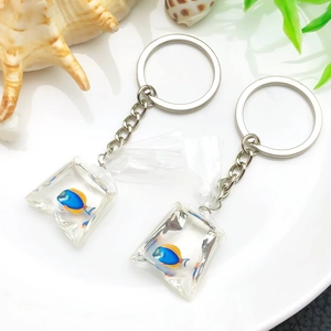 Detail of creative resin fish bag keychain with blue and yellow tropical fish inside