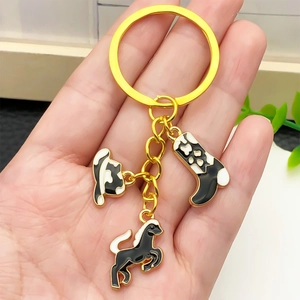Western cowboy keychain featuring gold-tone horse, hat, and boot charms with black enamel