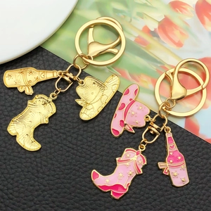 Macro shot of pink enamel western cowboy hat, boot, and star bottle keychain charms