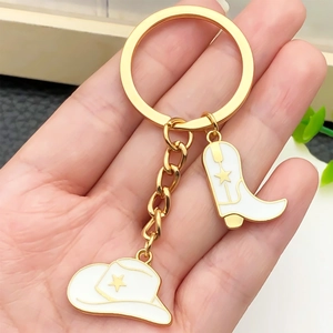 Porte-clés doré avec pendentifs chapeau et botte de cow-boy en émail blanc et étoiles