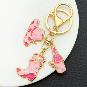 Pink western cowboy theme keychain with star hat, boot and bottle charms in gold finish