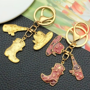 Detail of Western cowboy keychain with gold-plated hat, boot, and bottle charms