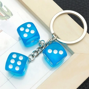 Portachiavi creativo con tre dadi in resina blu su un anello in metallo argento