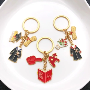 Golden graduation keychain set with academic cap, scroll and A+ badge for graduates