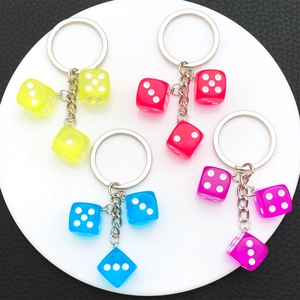 Creative resin dice keychains in four bright colors with silver rings on a white display
