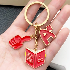 Creative red enamel graduation keychain with thumb, A+ and magic book charms