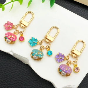 Trois porte-clés coquillages avec perles et fleurs en rose, bleu et violet