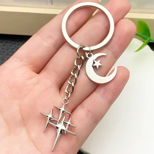Antique silver moon and star keychain held by hand for bags and keys ornament