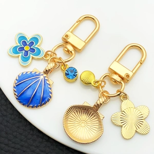 Porte-clés coquillage bleu et fleur océan doré avec cristaux bleus sur cuir noir
