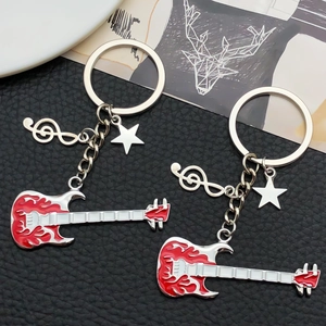 Close-up of guitar keychains with flame patterns, treble clef and star charms on leather