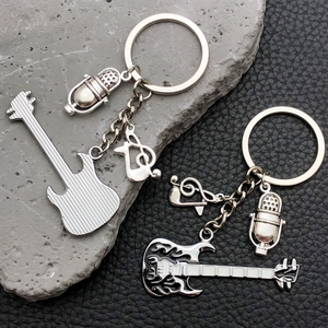 Detailansicht der Rockmusik-Gitarren- und Mikrofon-Schlüsselanhänger mit schwarzem Flammen-Emaille