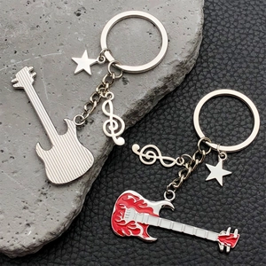 Detail view of guitar keychains with star charms and treble clef on textured leather