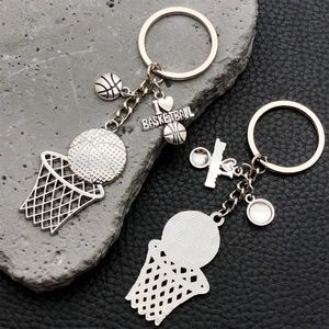 Détail du porte-clés basketball en argent avec breloque gravée sur fond cuir et pierre naturelle