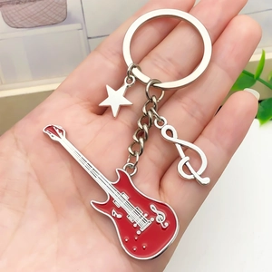 Red electric guitar keychain with musical note and star charms held in hand