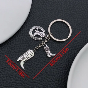 Western cowboy style keychain with silver horseshoe and boot pendants on black leather