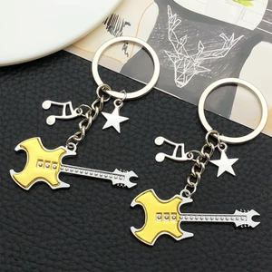 Detail view of yellow guitar keychain with musical notes and star pendant charms