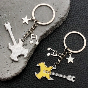 Detail of yellow guitar keychains with musical notes and star charms on leather