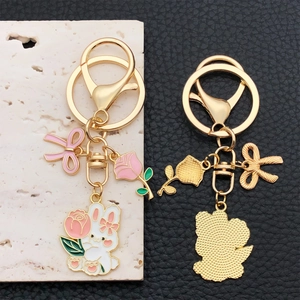 Pink ribbon and rose rabbit keychain set with white bunny charm in polished gold finish