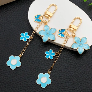 Porte-clés fleur de cerisier et papillon bleu émail avec matériel doré sur pierre blanche