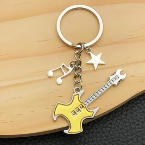 Music themed keychain with yellow electric guitar, musical note and star charm on wood