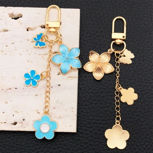 Porte-clés fleurs de cerisier bleu et papillon avec fermoir en U doré brillant
