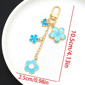 Détail du porte-clés fleurs de cerisier et papillon en émail bleu avec ses dimensions