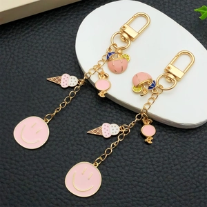 Porte-clés crème glacée rose et visage souriant avec pendentifs en métal doré