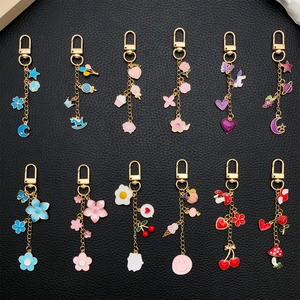 Lot de 12 porte-clés émaillés dorés avec charms étoile et cœur sur fond cuir noir