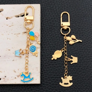 Blue enamel crown rocking horse keychain set with golden balloon and lollipop charms