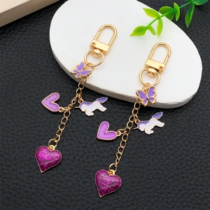 Set de porte-clés dorés avec breloques émaillées violettes de papillon, licorne et coeur