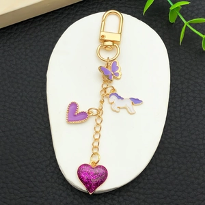 Porte-clés doré avec papillon violet, licorne en émail et breloques en forme de cœur poli