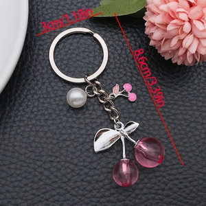 Kirsch-Schlüsselanhänger in Rosa mit Perlen und silbernen Blättern auf schwarzem Leder