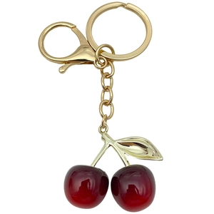 Creative resin red cherry keychain with gold leaves and dual lobster clasp on white background